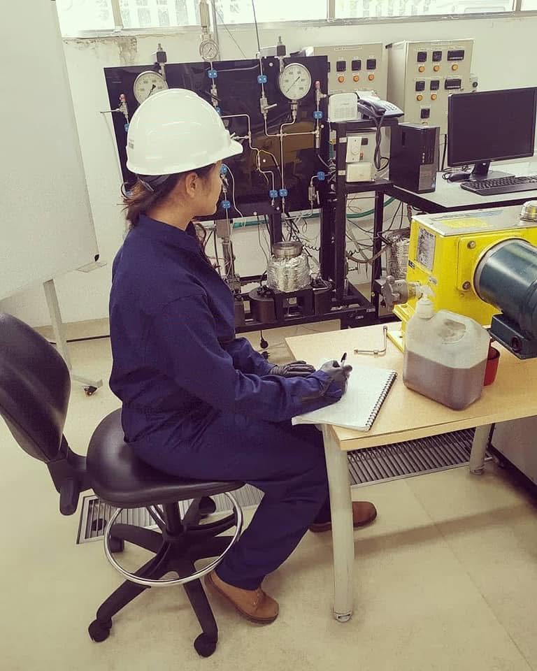 Nuestra fundadora en pruebas de banco: overol, casco y guantes — los proyectos Black Belt se miden en la máquina, no en la sala de juntas.